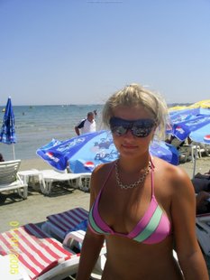 Девчонка позирует на камеру на курорте топлесс